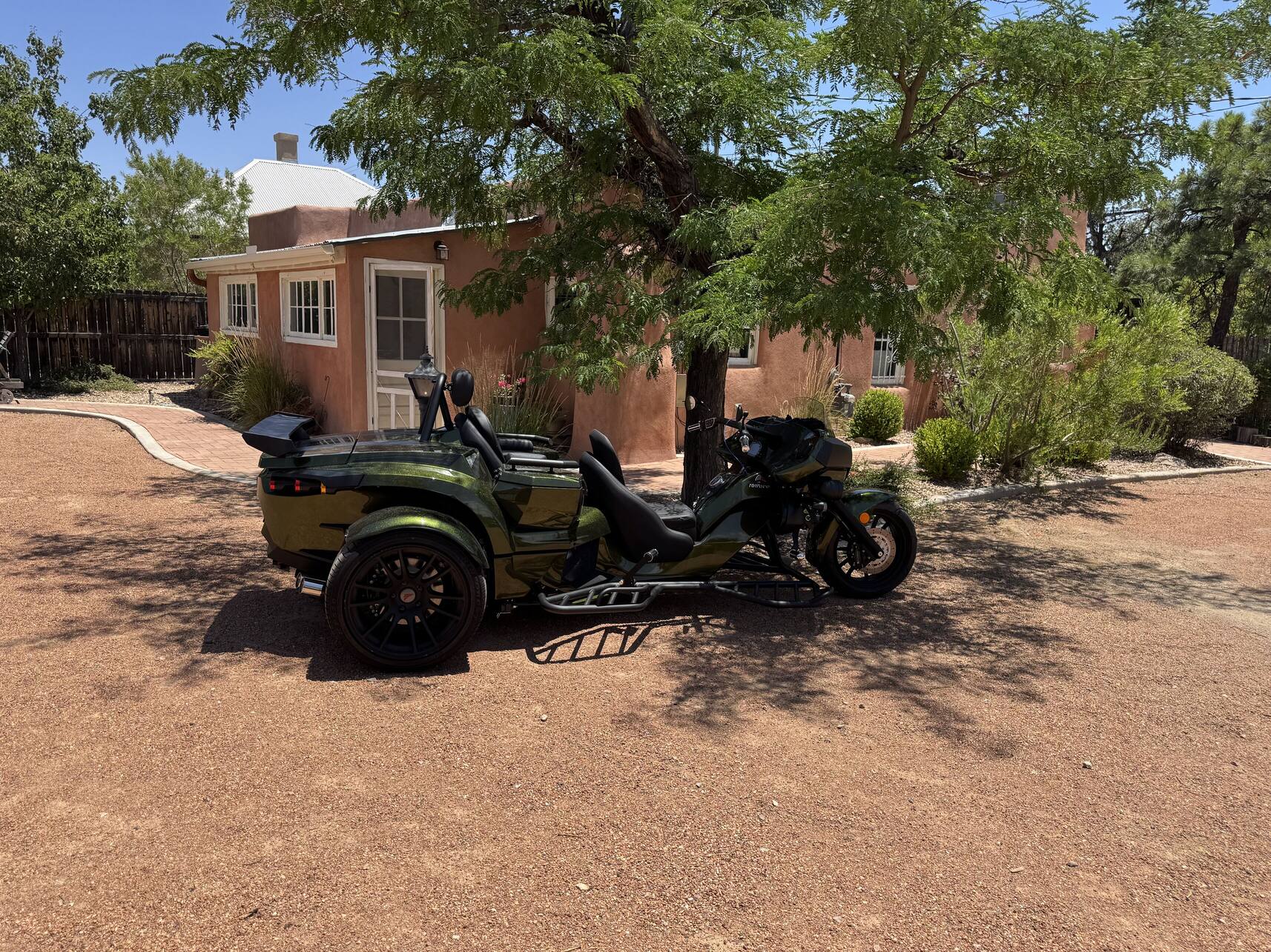 Rewaco trike in front of an adobe home